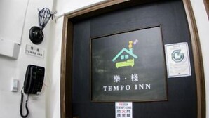 A door with a sign for Tempo Inn, a telephone, and a fire safety sign. - Tempo Inn @david Mansion (Kowloon)