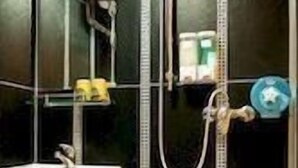 A bathroom with a toilet, a sink, and a shower. - Tempo Inn @david Mansion (Kowloon)
