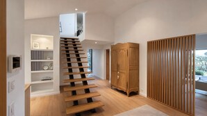 Een modern interieur met een houten trap, inbouwkasten, een kledingkast en een schuifdeur.