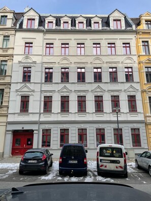 Eine Reihe mehrstöckiger Gebäude mit einheitlichem Fensterdesign und roten Türen.