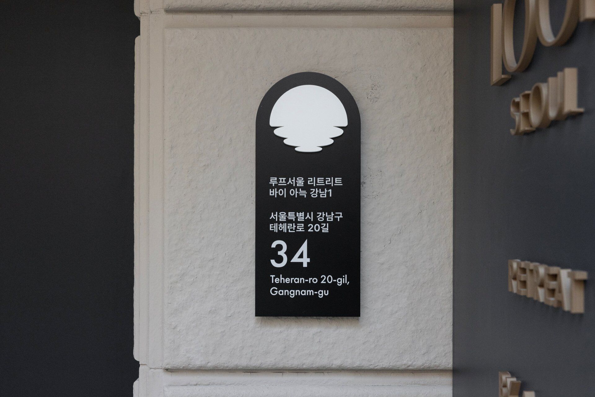 A black and white sign with a silhouette of a person, Korean text, and the number 34.
