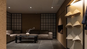 A modern interior with a sofa, a coffee table, and a wall-mounted lamp. - LOOP Seoul Hotel Retreat by Anook Seoul Gangnam 1 (Seoul)