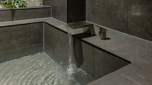 A modern water feature with a cascading design, set in a dark-toned stone structure. - Anook Ryokan Hotel Daejeon Yongjeon (Daejeon)