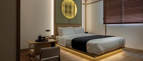 Une chambre moderne avec un lit, une table de chevet, une chaise et une fenêtre circulaire fixée au mur.