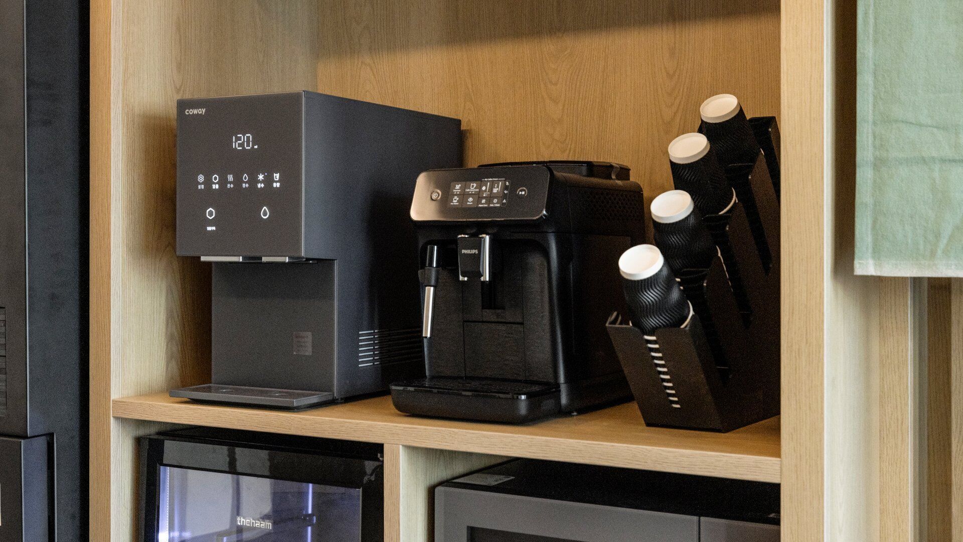 A coffee machine and a water dispenser on a shelf.