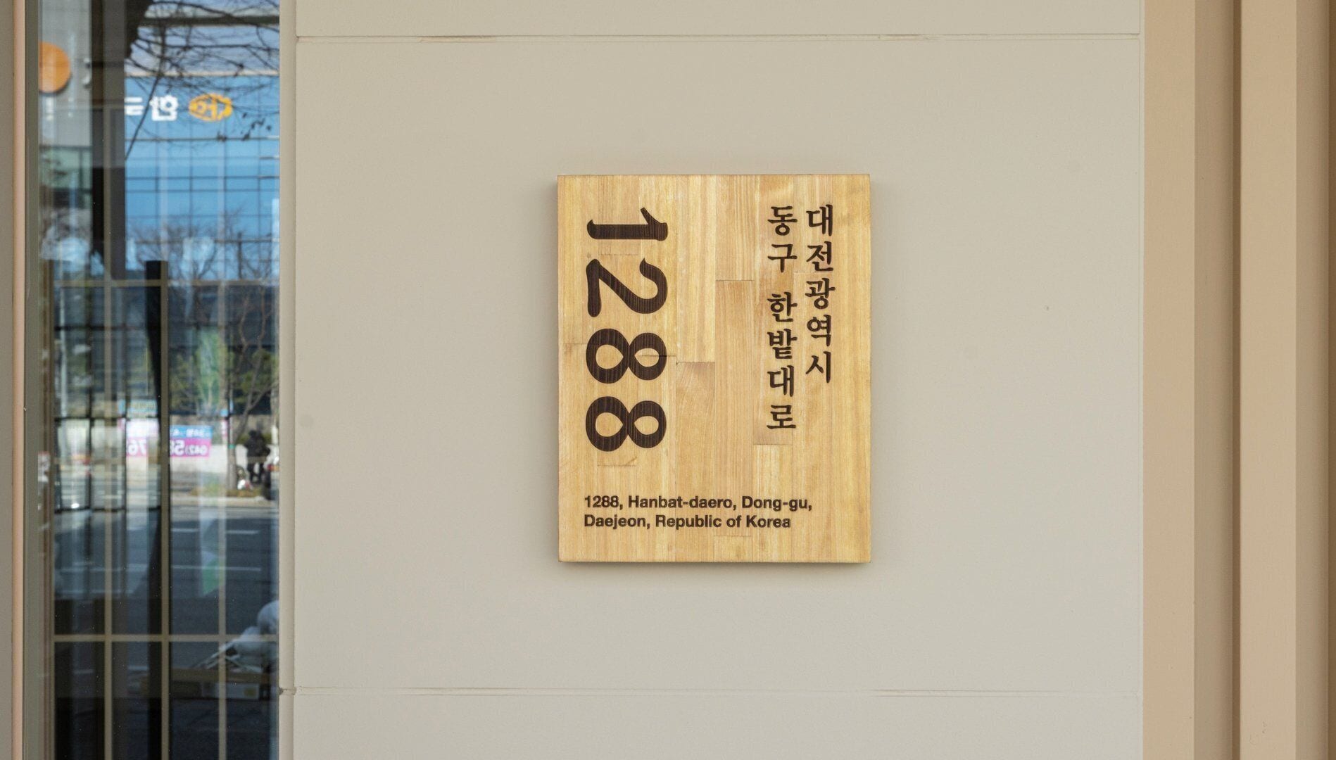 Un letrero de madera con el número 1288 y texto coreano que indica una ubicación en Daegu, República de Corea.