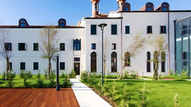 A modern building with a white facade, multiple windows, and a well-maintained lawn. - Charming Apartment for 4 Guests – Relax and Comfort near Venice (Venezia)