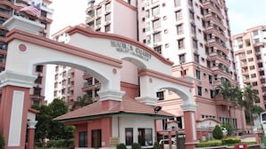Um edifício de vários andares com uma arcada imponente identificada como 'MARINA COURT RESORT'.