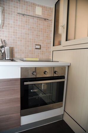 A kitchen with a built-in oven, a countertop, and a tiled backsplash. - Traces in the village. Vacation Home. The Perfect Balance of Style and Position (Putignano)