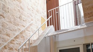 A stone staircase leading to a door with a 'WELCOME' mat.