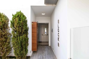 A narrow hallway with a wooden door and a wall-mounted sign reading 'BLOCK B'.