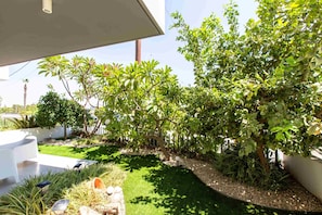 A landscaped garden with a variety of plants and a lawn. - Lemon Tree 1-BR Apt & Pool in Livadia (Larnaca)