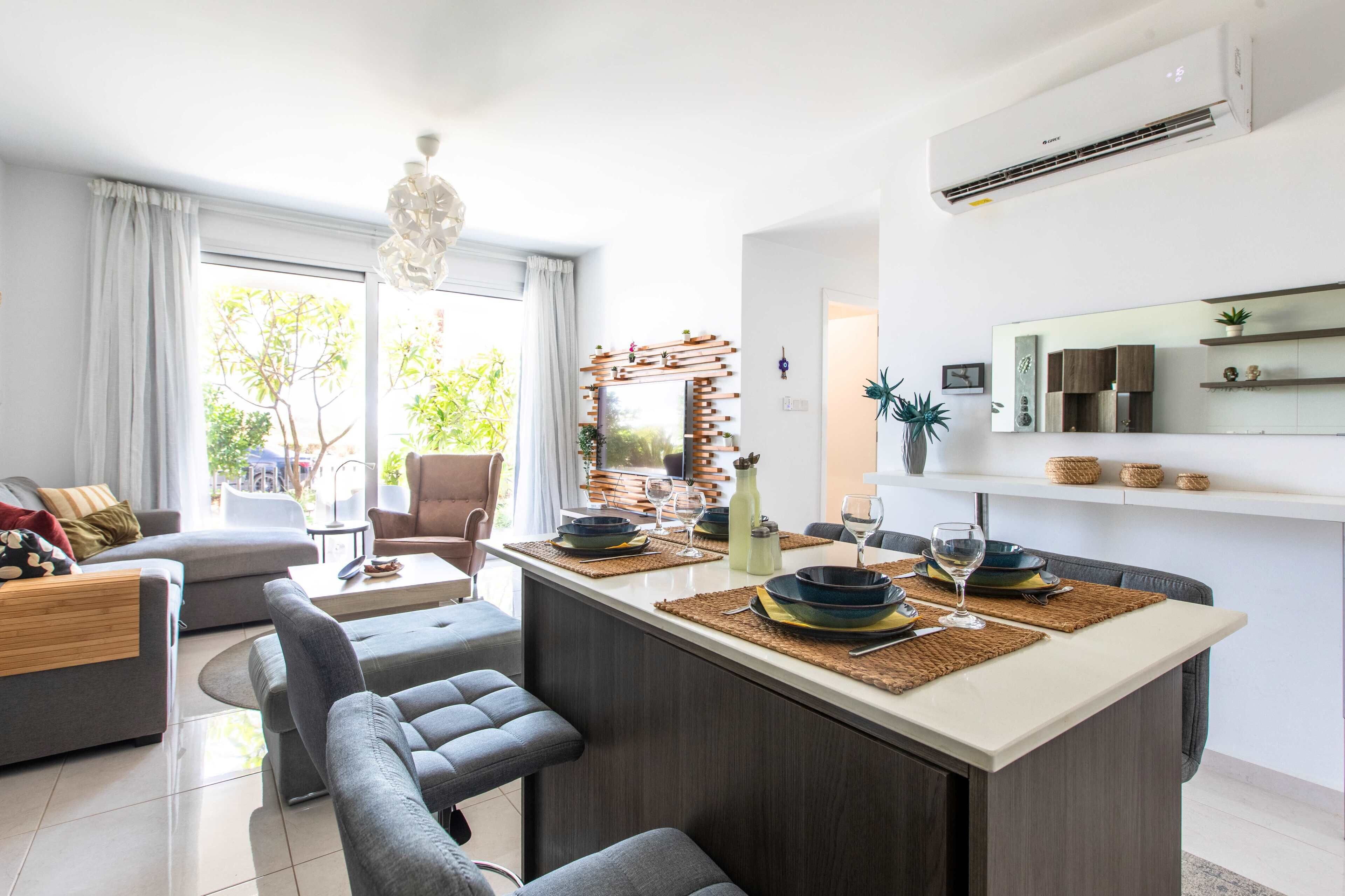 Un espacio moderno para vivir con una isla central, zona de estar y cocina equipada.