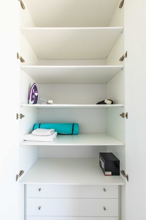 A white closet with multiple shelves, a hanging rod, and a storage box. - Lemon Tree 1-BR Apt & Pool in Livadia (Larnaca)