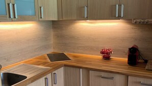 A kitchen with wooden cabinets, a stainless steel sink, and a countertop. - Les 2 alpes, at the foot of the slopes - apartments (Les Deux Alpes)