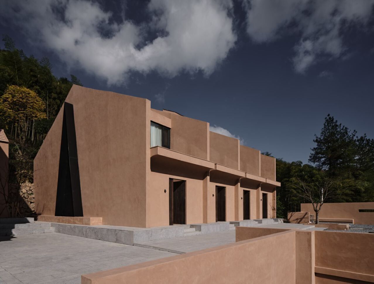Un edificio moderno con tejado plano, ventanas rectangulares y fachada simétrica.