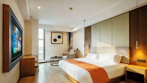 A modern hotel room with a large bed, a desk, a chair, and a TV mounted on the wall. - spiderHoteTwo (Hangzhou)