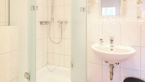 Ein Badezimmer mit Dusche, Badewanne, Waschbecken und Toilette.