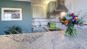 Eine Küche mit einer klaren Glasvase und Blumen auf der Arbeitsfläche.