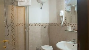 A bathroom with a shower, toilet, sink, and a mirror. - Hotel Villa Rosa (Modica)