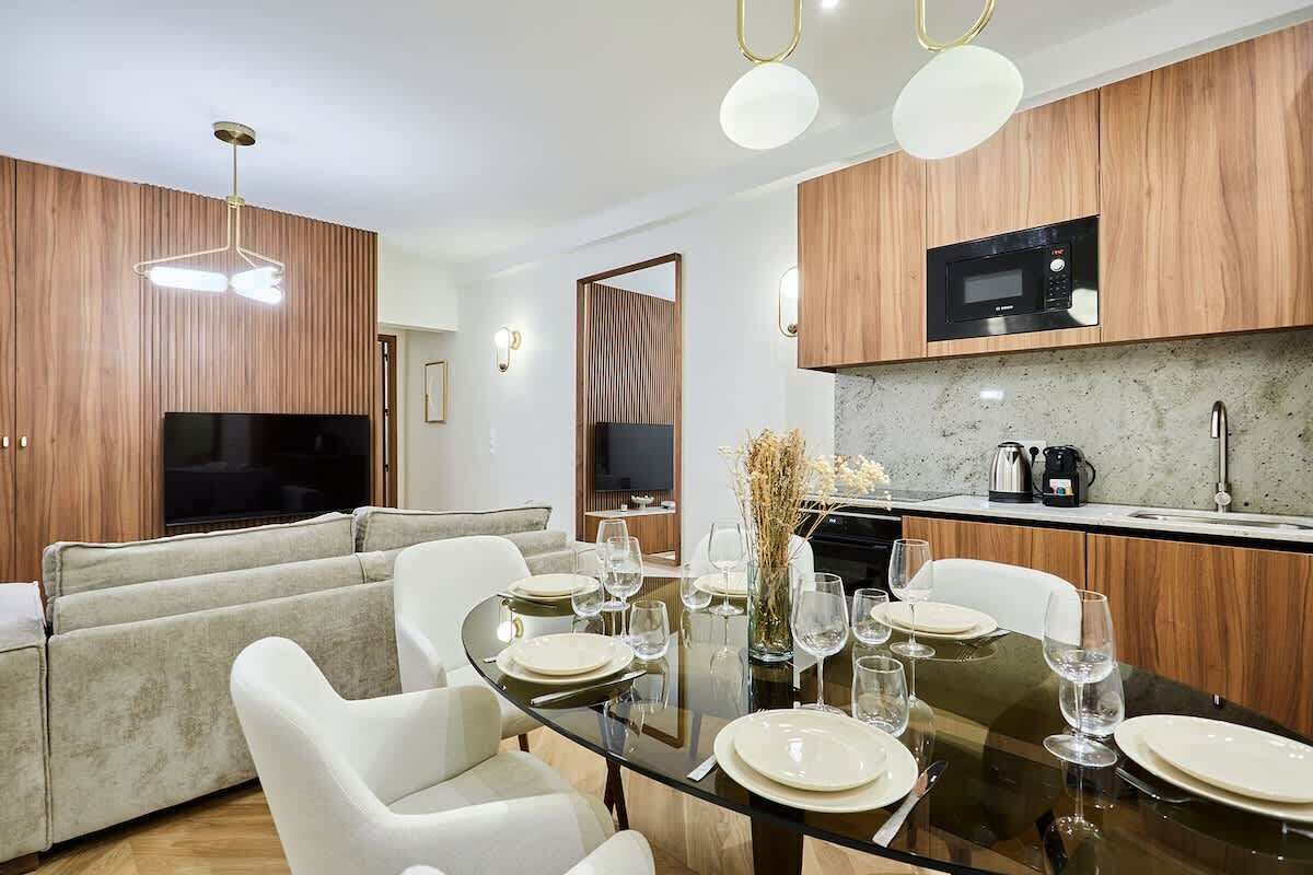 Una cocina moderna con armarios de madera, microondas integrado y encimera de granito.