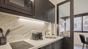 A modern kitchen with a built-in microwave, a coffee maker, and a sink. - Modern Suite with Patio Boulogne-Billancourt (Boulogne-Billancourt)