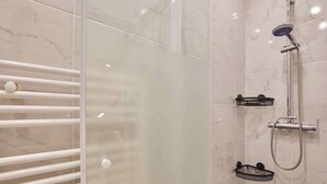 A modern bathroom with a glass shower enclosure, a white towel rack, and a black shower tray. - Modern Suite with Patio Boulogne-Billancourt (Boulogne-Billancourt)