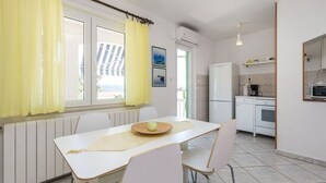 Una cocina compacta con comedor, refrigerador y microondas.