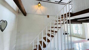 A staircase with white railings and wooden steps, a hanging light fixture, and a heart-shaped decoration on the wall. - 4 Person Holiday Home in Tomelilla (Tomelilla)