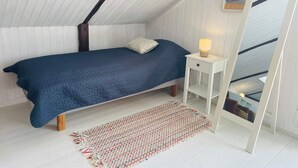 A bedroom with a bed, bedside table, lamp, and a view of the outside through a window. - 4 Person Holiday Home in Tomelilla (Tomelilla)