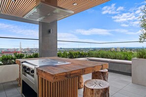 An outdoor kitchen with a view of the city skyline. - Stylish Apartment in Ikebana Complex (Melbourne)