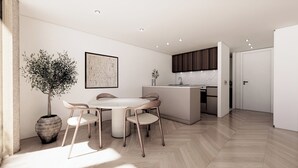Eine moderne Küche mit Marmorarbeitsplatte, ein Essbereich mit rundem Tisch und Stühlen sowie eine Kühlpflanze.