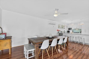 Cozinha moderna com armários brancos, uma ilha central e banquetas de bar.