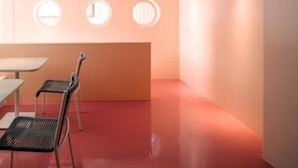 Un interno moderno con soffitto curvo, finestre rotonde e pavimento rosso.