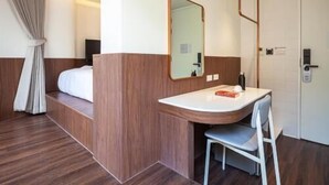 Una camera d'albergo con un letto, un bagno dotato di specchio, lavabo e una sedia.