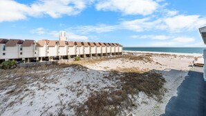 A beachfront hotel with multiple buildings, a sandy beach, and a clear sky. - Lani Kai 230 Gulf Coast Condo. Walk to Beach + Pools + Balcony Views! (Gulf Shores)