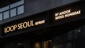 Um edifício com placas indicando 'LOOP SEOUL RETREAT' e 'BY ANOOK SEOUL HONGDAE'.