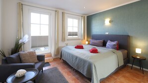 Ein Hotelzimmer mit Bett, Sofa, kleinem Tisch und Lampe.