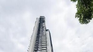 Un edifici modern i alt, amb un disseny vertical destacat, que presenta múltiples plantes i una combinació d'elements de façana de vidre i sòlid.