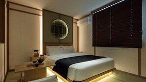 A modern hotel room with a bed, bedside table, and a wall-mounted air conditioning unit. - Anook Ryokan Hotel Daejeon Daeheung (Daejeon)