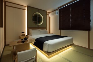 A modern hotel room with a bed, bedside table, and a wall-mounted air conditioning unit. - Anook Ryokan Hotel Daejeon Daeheung (Daejeon)
