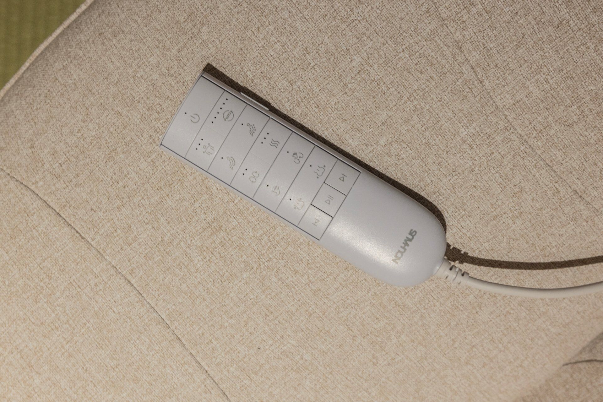 A remote control on a beige couch.