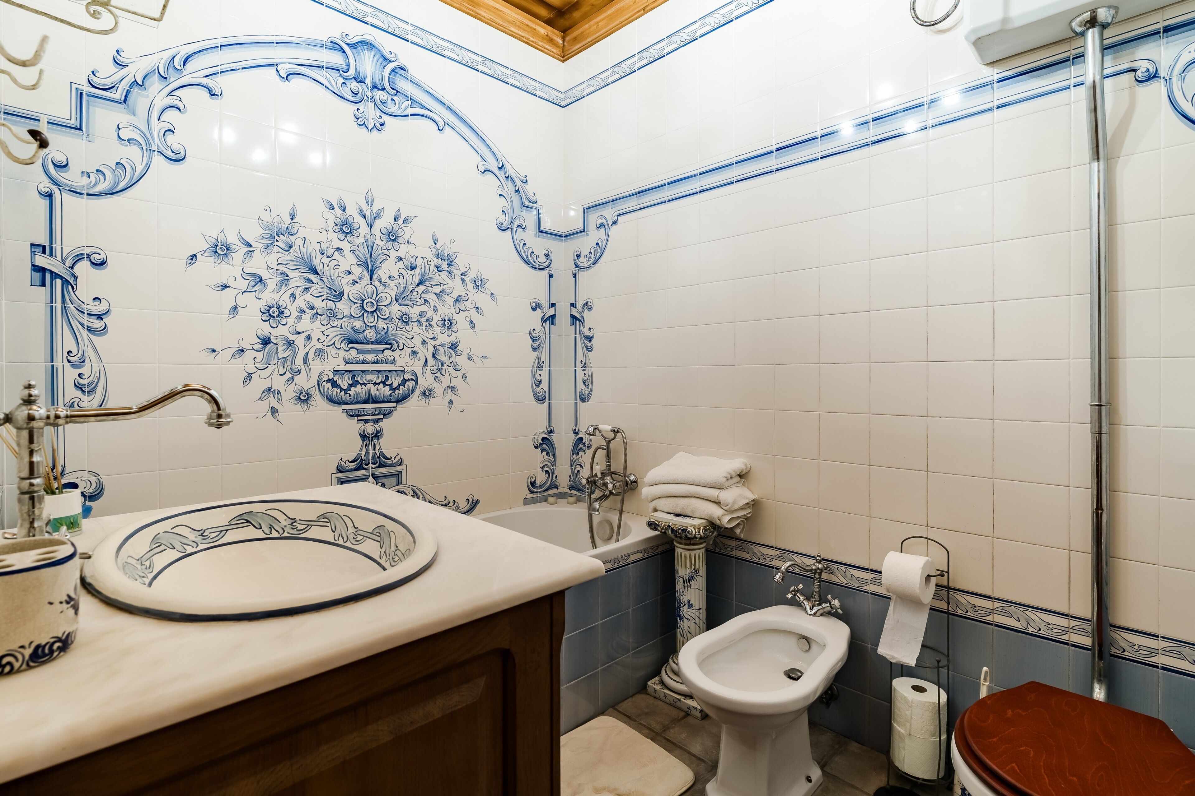 Baño con lavabo, bidé, inodoro y un diseño de azulejos decorativos.