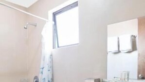 Un baño con inodoro, lavabo y ducha.
