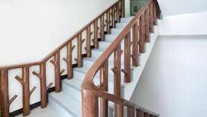 Una escalera con barandilla y balaustradas de madera que lleva a un piso superior.