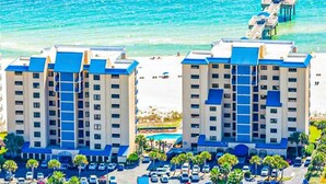 Un hotel con diversi piani, piscina e vista sulla spiaggia.