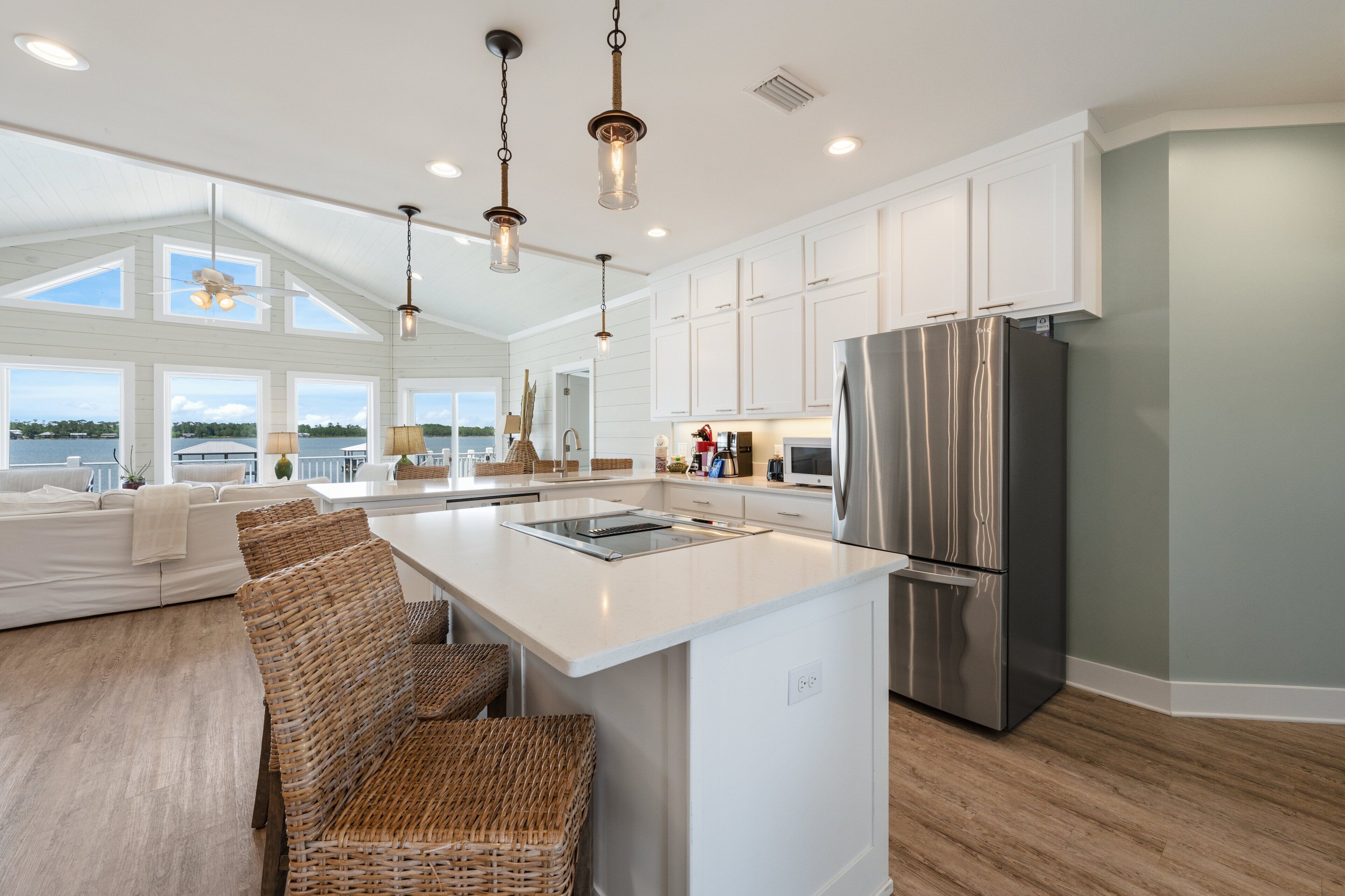 A spacious kitchen with a large island, stainless steel appliances, and a view of the outdoors.
