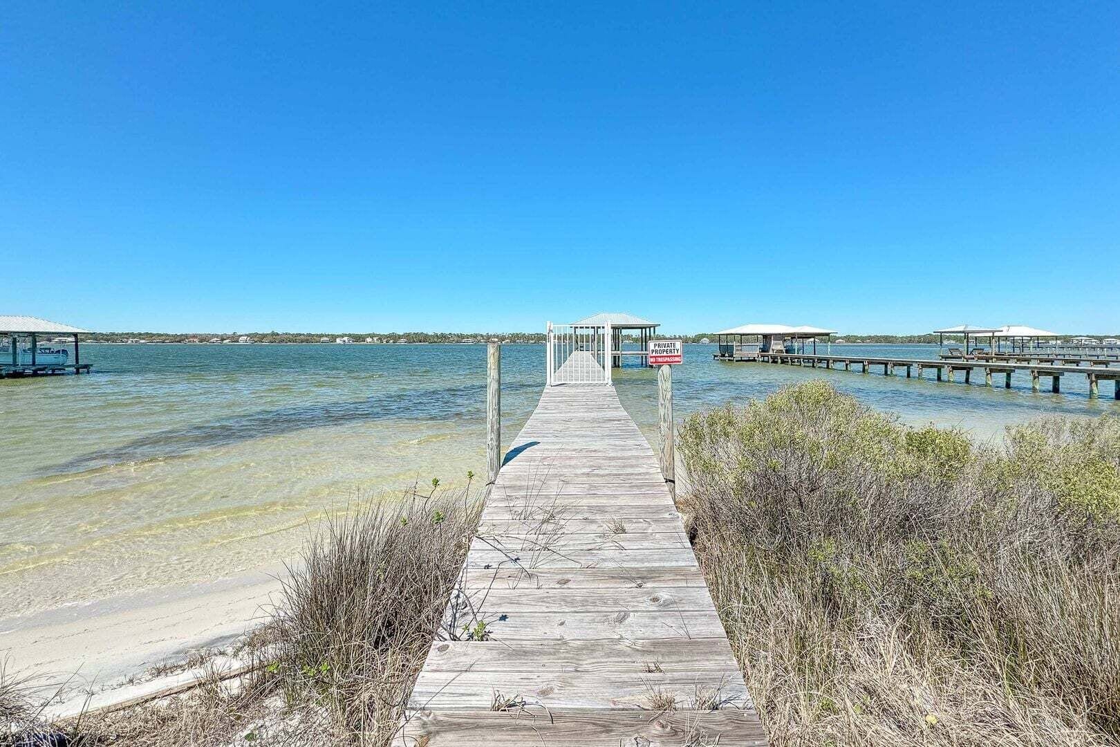 A wooden pier leading to a gazebo, with a 'PRIVATE PROPERTY' sign visible.