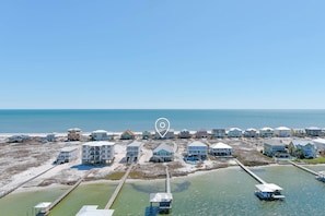 A coastal residential area with houses, a pier, and a beach. - Beach House on the Bay With Private Dock (Gulf Shores)