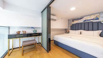 Una habitación de hotel moderna con una cama, un escritorio con silla y una ventana.